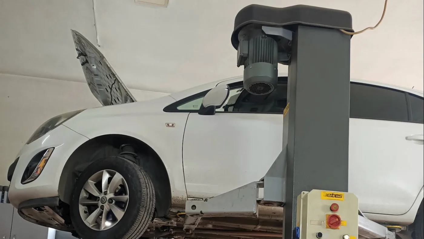 Mesa atölyesinde lift üzerinde bir Opel Corsa